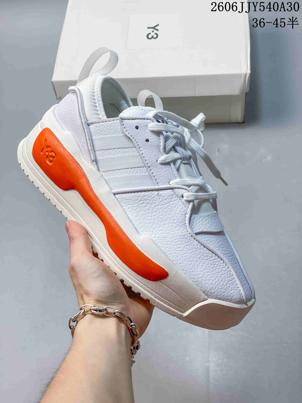 White Y-3 Rivalry sneaker with an orange side accent.