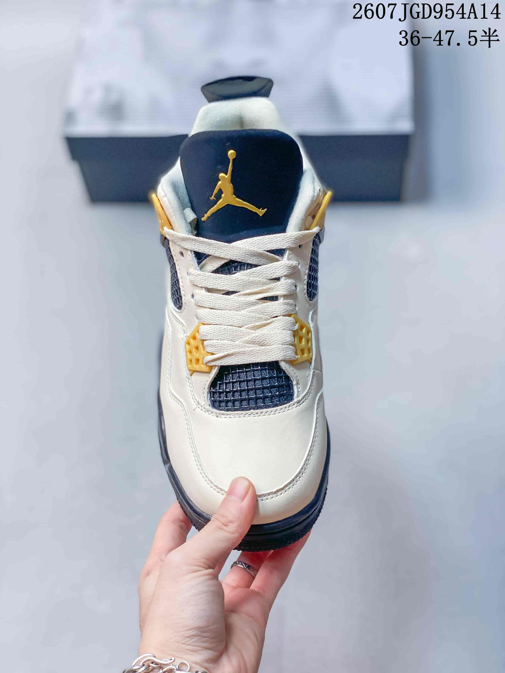 Top view showing the off-white toe, white laces, navy mesh panels, and gold tongue branding.