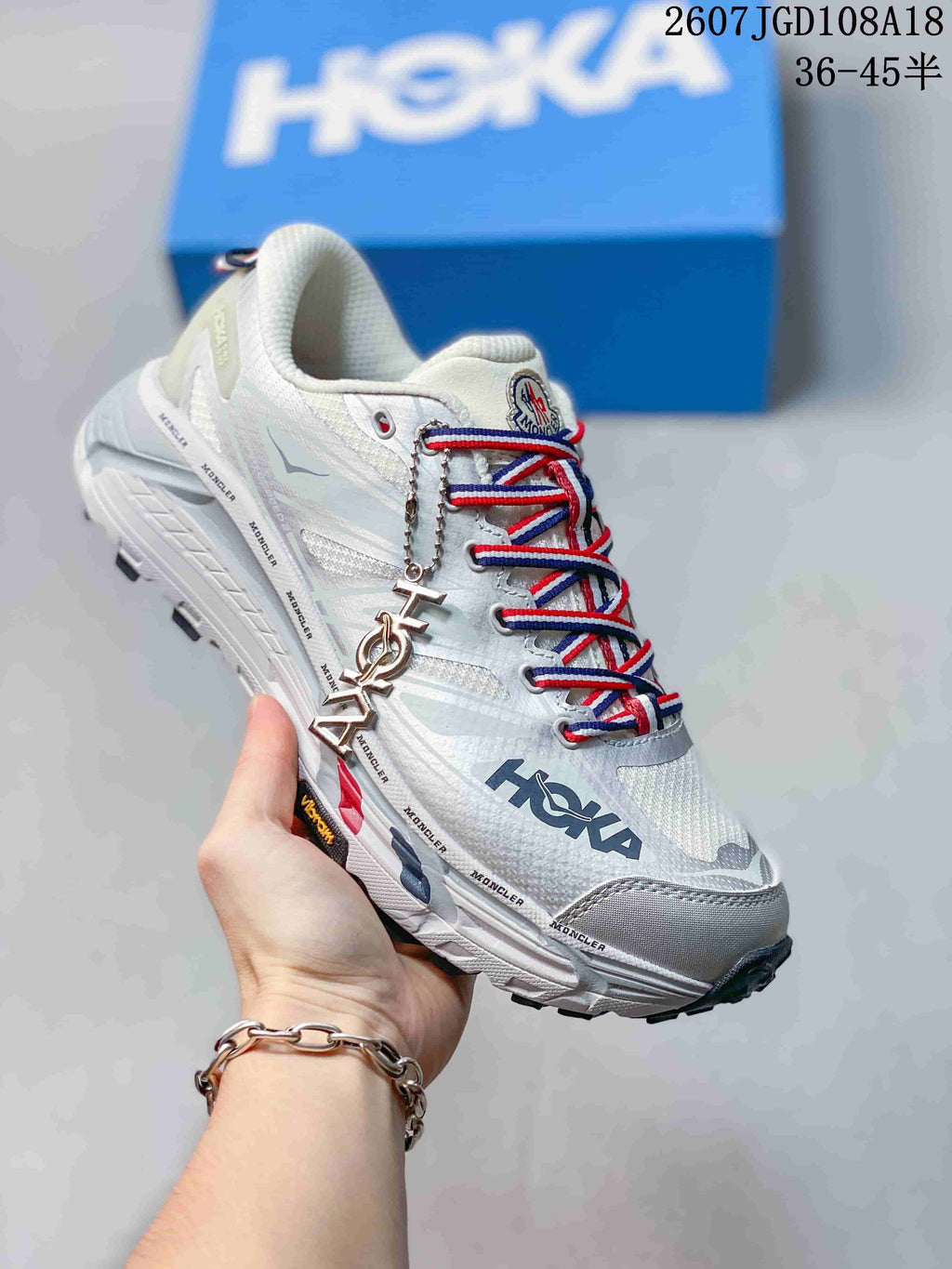 White HOKA Mafate Speed 2 sneaker with red and blue lace details and graphic side branding.