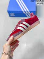 Side profile showing the burgundy upper, white stripes, red laces, and low gum sole.