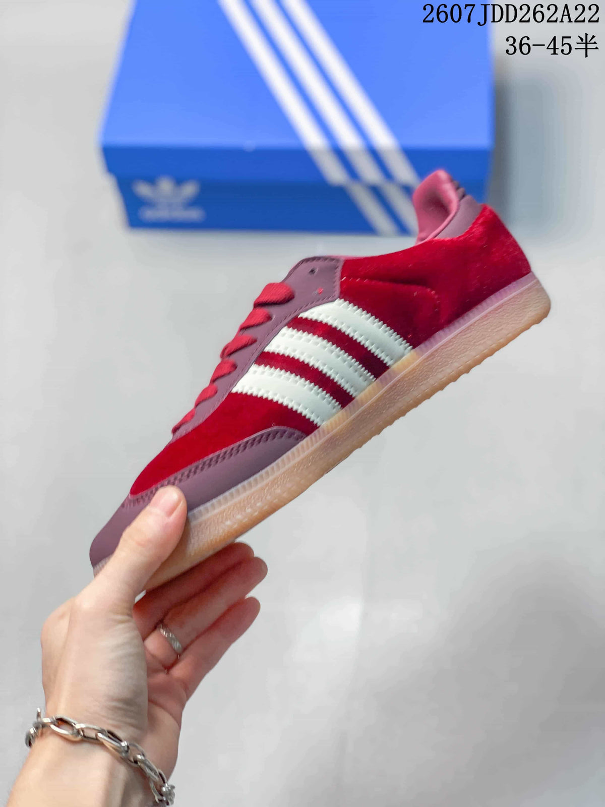 Side profile showing the burgundy upper, white stripes, red laces, and low gum sole.