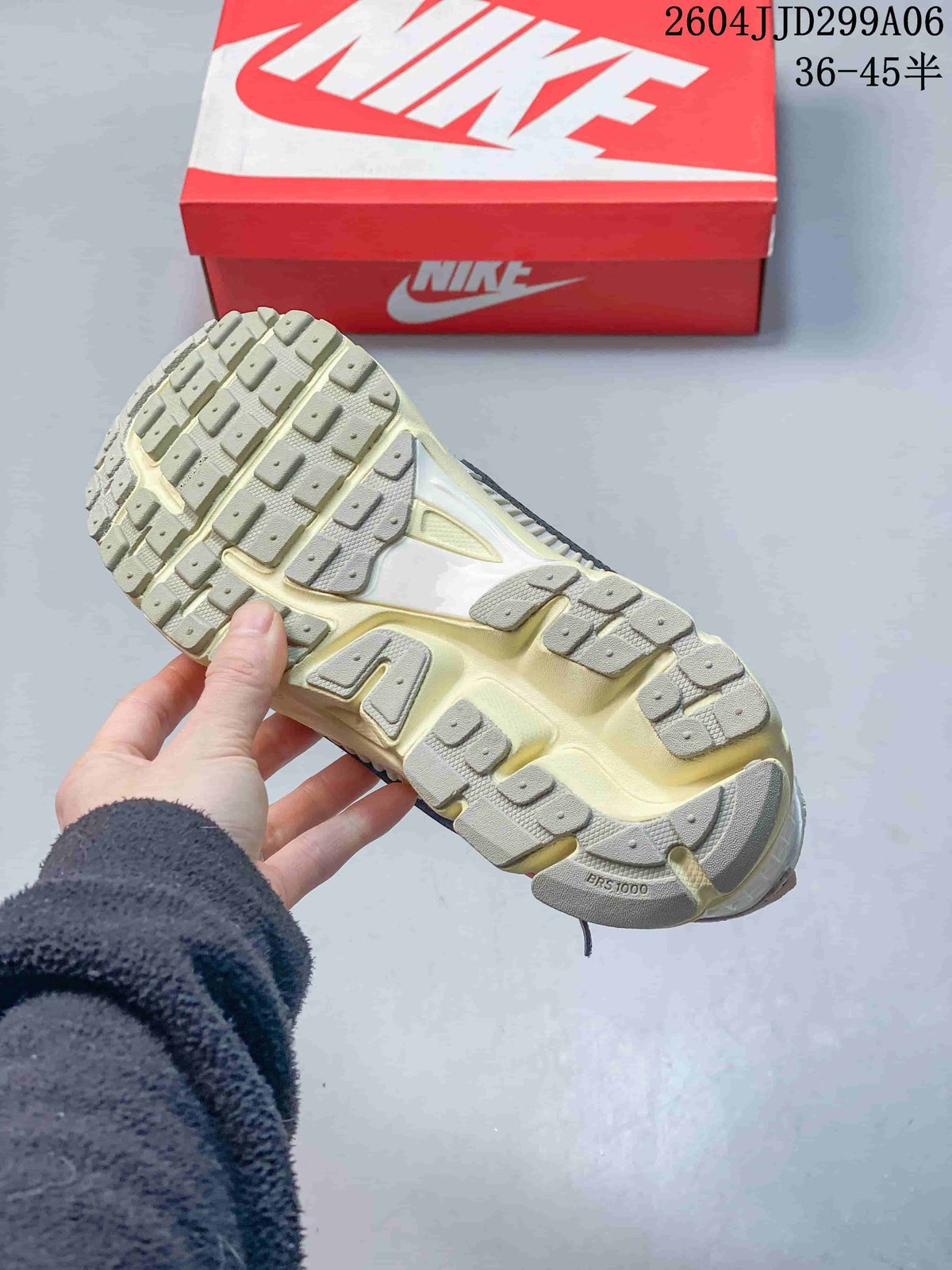 Outsole view of a Nike Zoom Vomero 5 sneaker with segmented cream and gray traction sections.