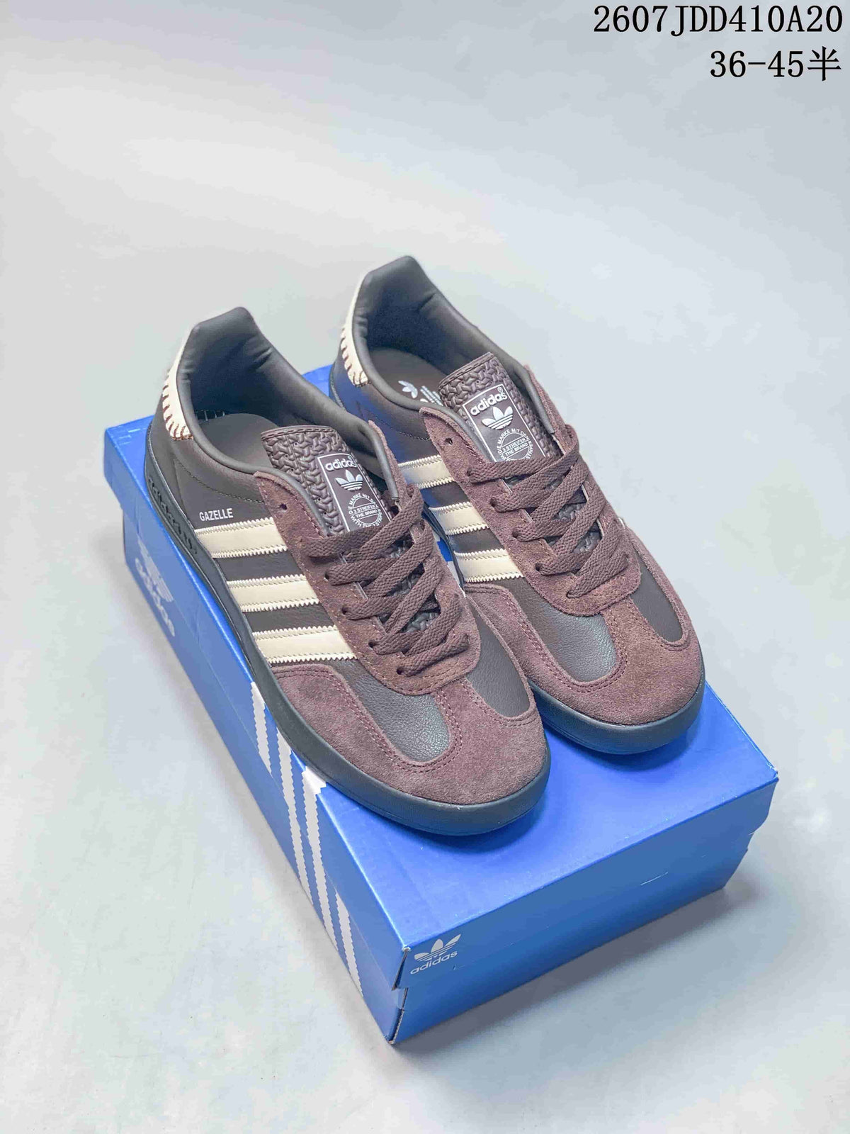 Pair of brown and cream Adidas sneakers displayed on a blue shoebox, with style code 2607JDD410A20 and size range 36–45 shown above.