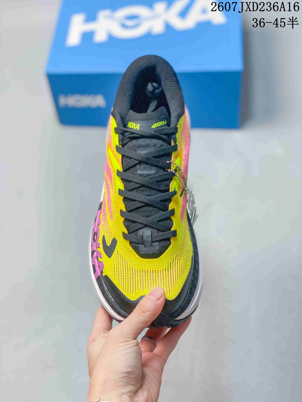Top view of the MAFATE X shoe showing black laces, a yellow and pink upper, and visible Hoka and MAFATE branding on the tongue.