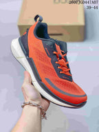 Angled front-side view of an orange and navy ECCO sneaker showing the lace-up construction, textured upper, pull tab, and contrasting sole.