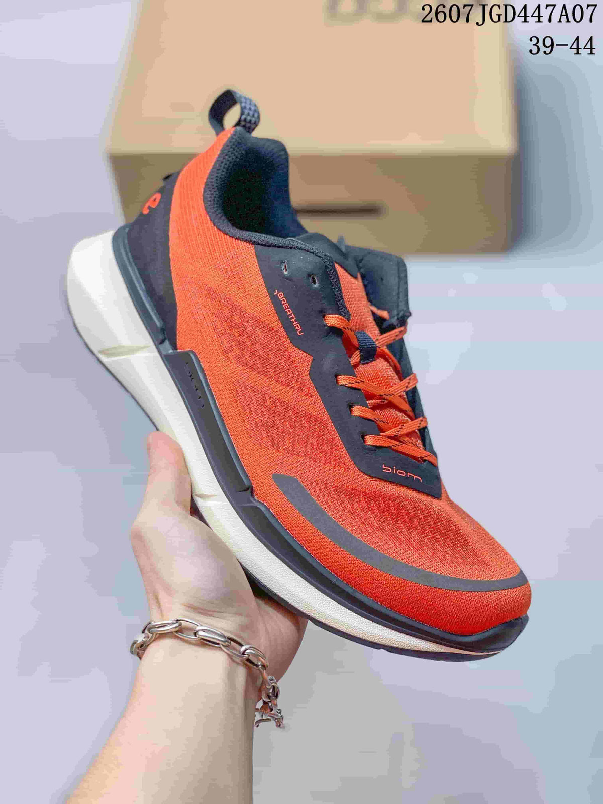 Angled front-side view of an orange and navy ECCO sneaker showing the lace-up construction, textured upper, pull tab, and contrasting sole.