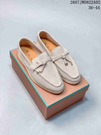 Pair of pale gray-beige loafers with moc-toe seams and small metal accents