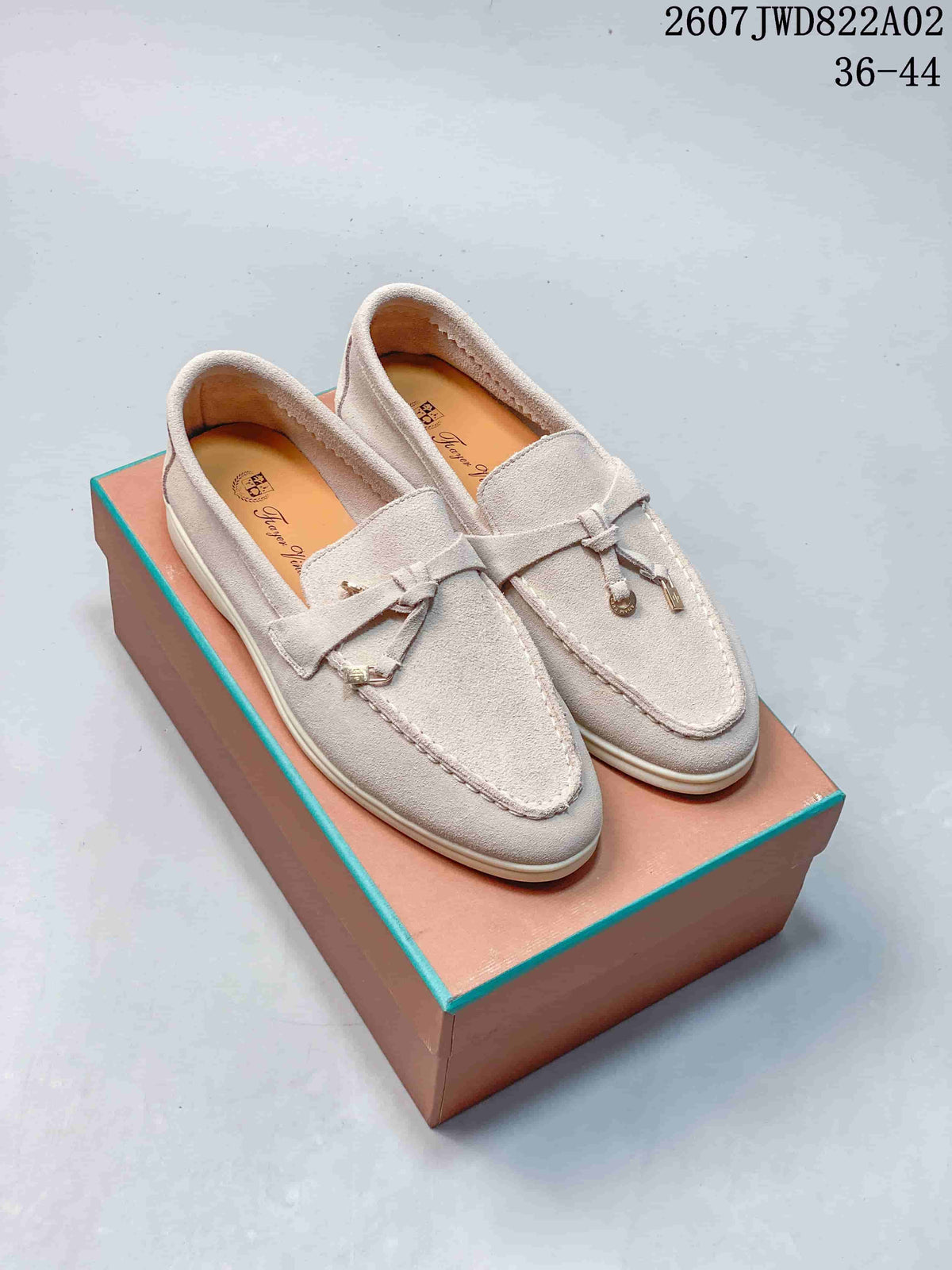 Pair of pale gray-beige loafers with moc-toe seams and small metal accents