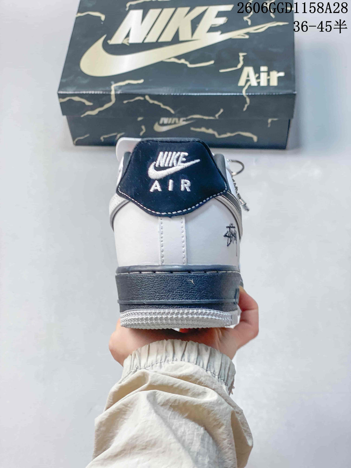 Rear view showing a navy heel tab, white heel panel, and dark midsole.