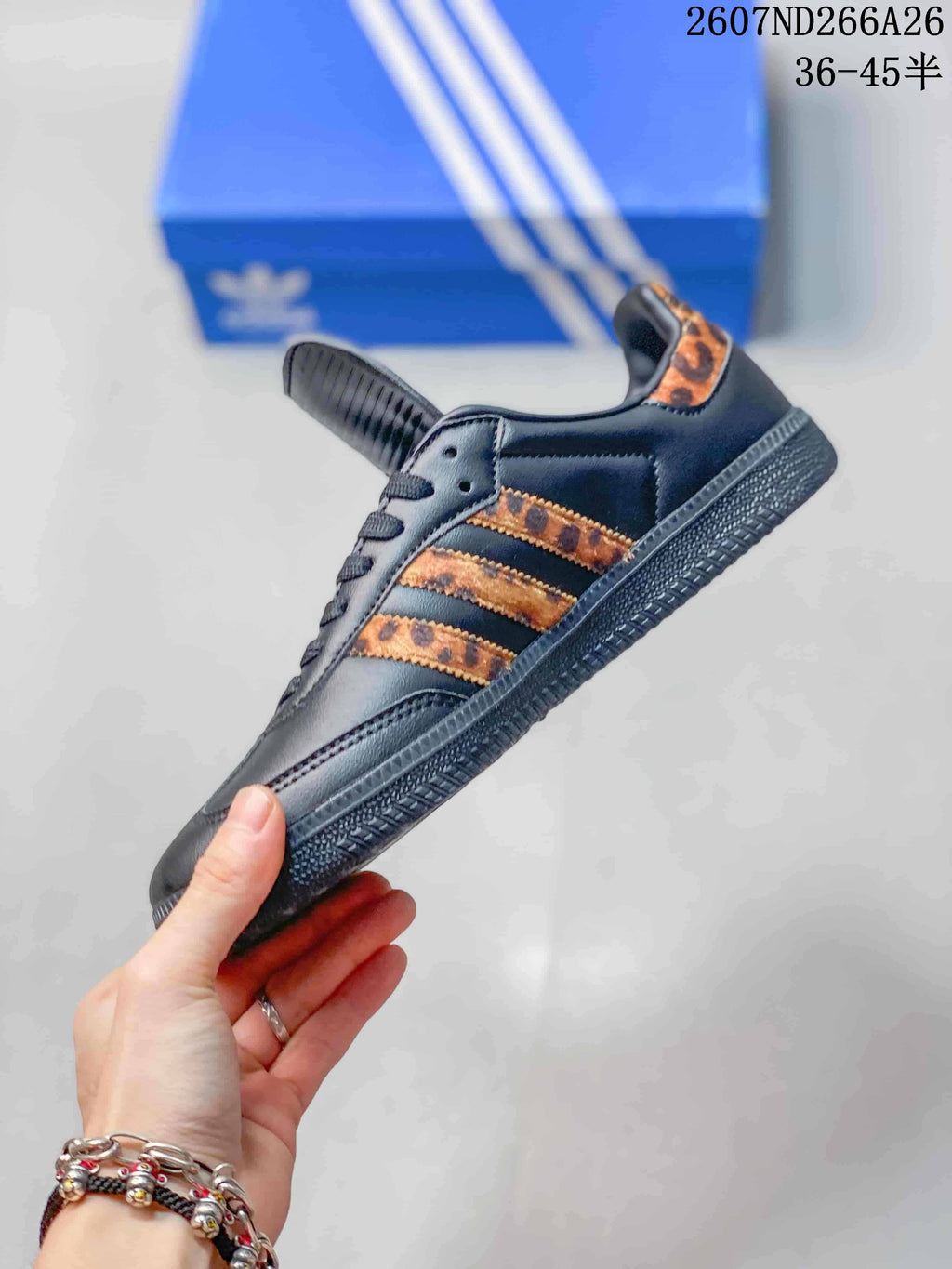 Side view highlighting the black upper, three orange-brown patterned stripes, lace area, and textured outsole.