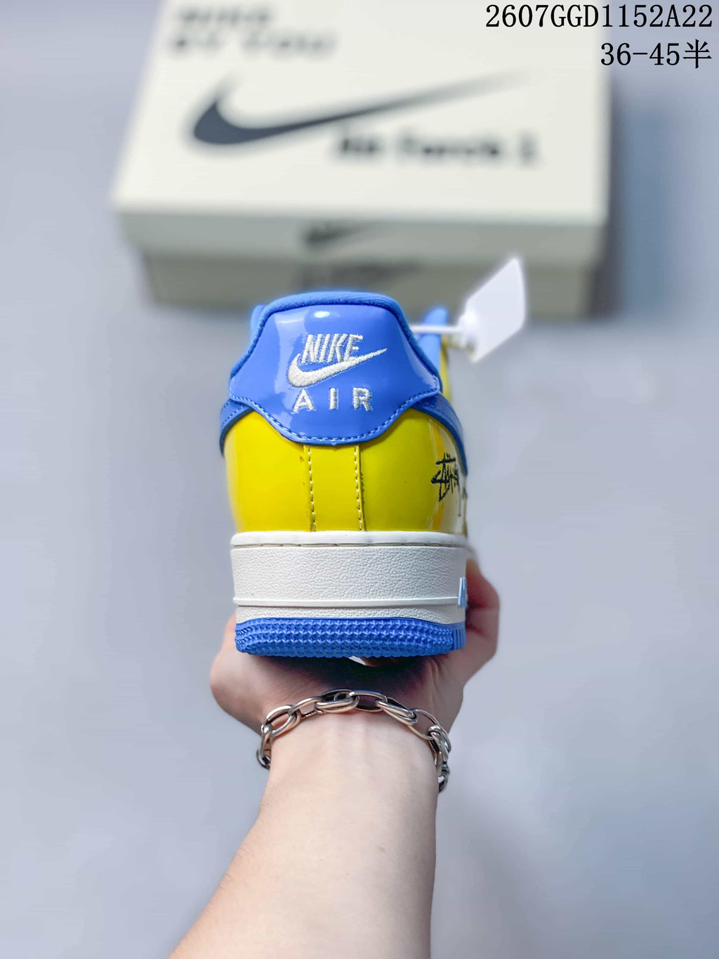 Rear view of the multicolor Nike Air Force 1 sneaker showing the blue heel tab, yellow upper, white midsole, and blue outsole.