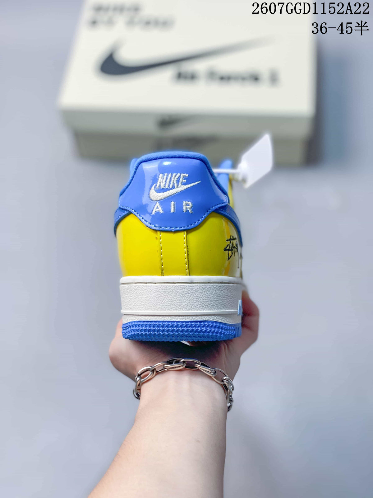 Rear view of the multicolor Nike Air Force 1 sneaker showing the blue heel tab, yellow upper, white midsole, and blue outsole.