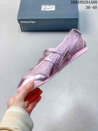 Side view of the pink metallic sneaker showing the buckle straps, stitched upper panels, and low-profile sole.
