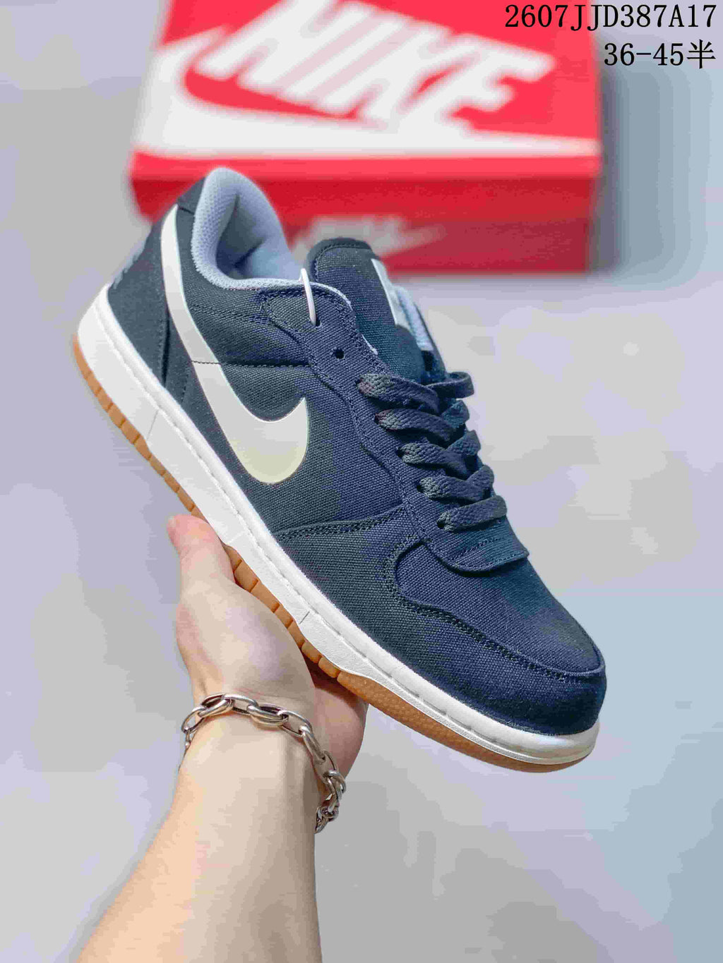 Angled side view of the navy sneaker showing the white Swoosh, stitched panels, white midsole, and gum outsole.