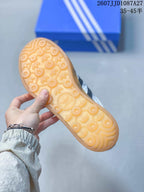 Close view of the gum-colored outsole showing a circular and trefoil-patterned tread.