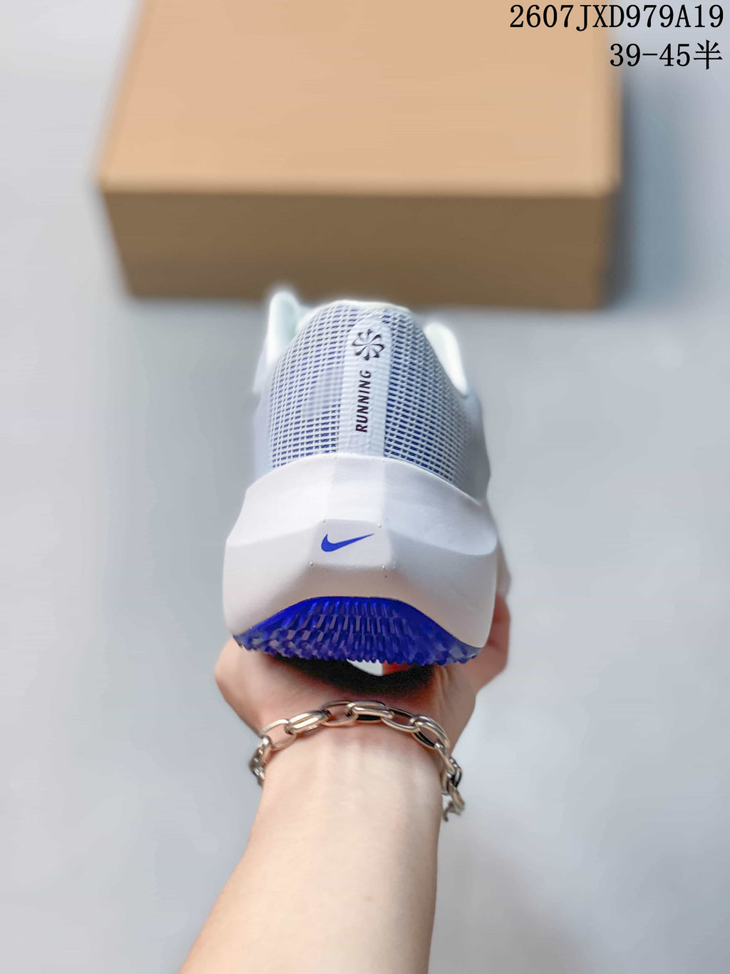 Rear view of a white Nike running sneaker with a blue logo and blue outsole detail.