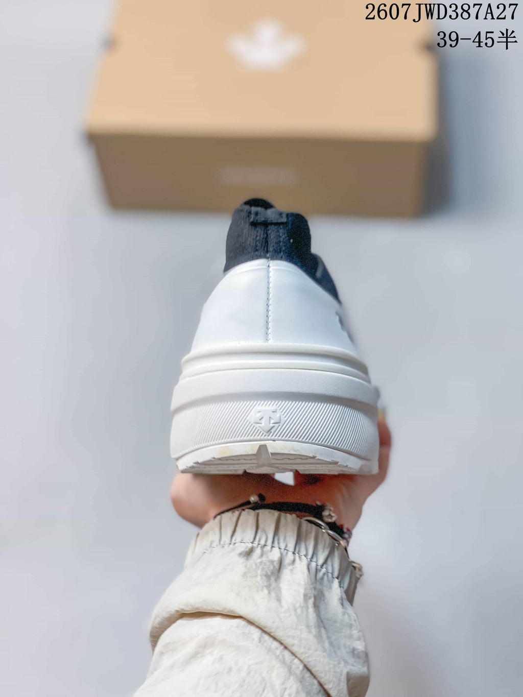 Rear view showing the white heel, navy pull tab, and raised heel branding.