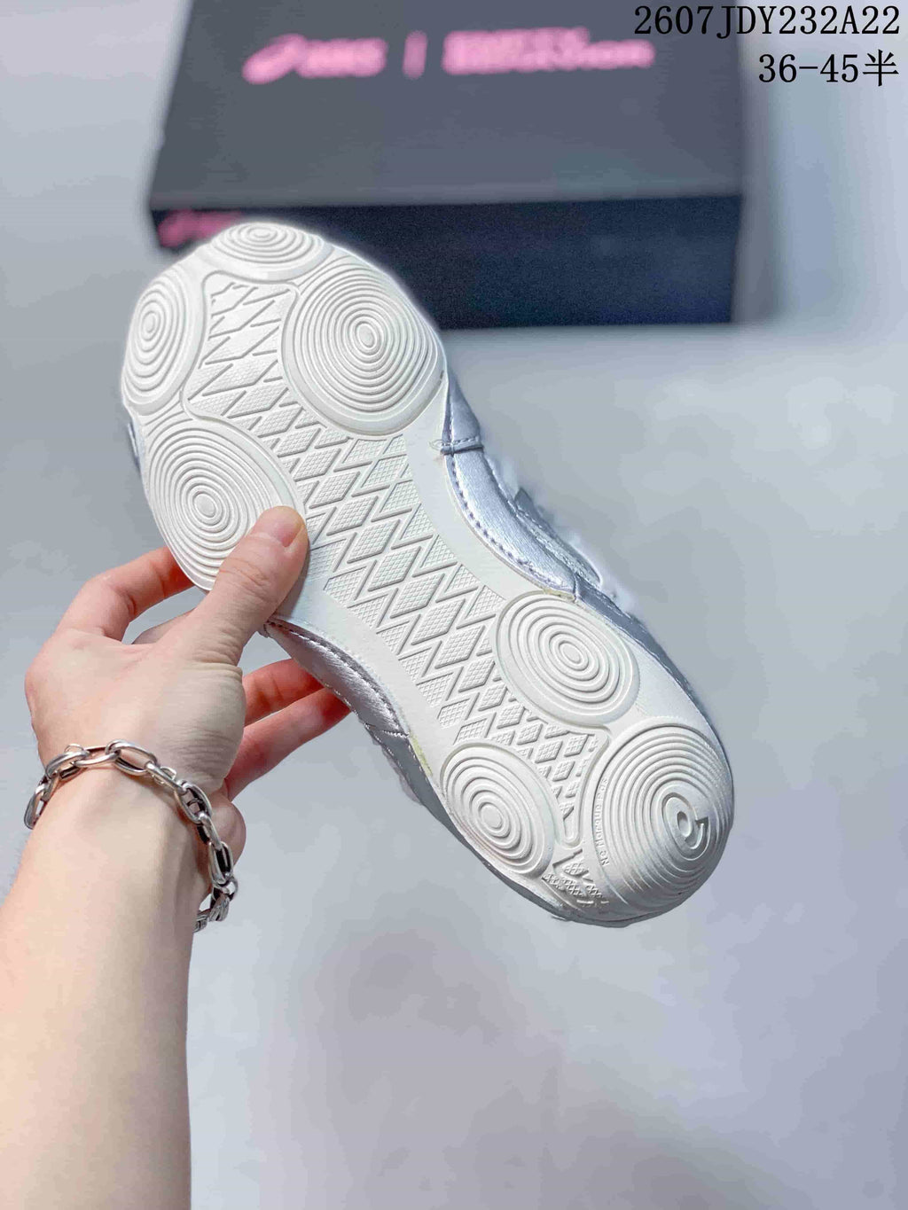 Close-up of the white outsole showing circular tread zones and a textured central traction pattern.