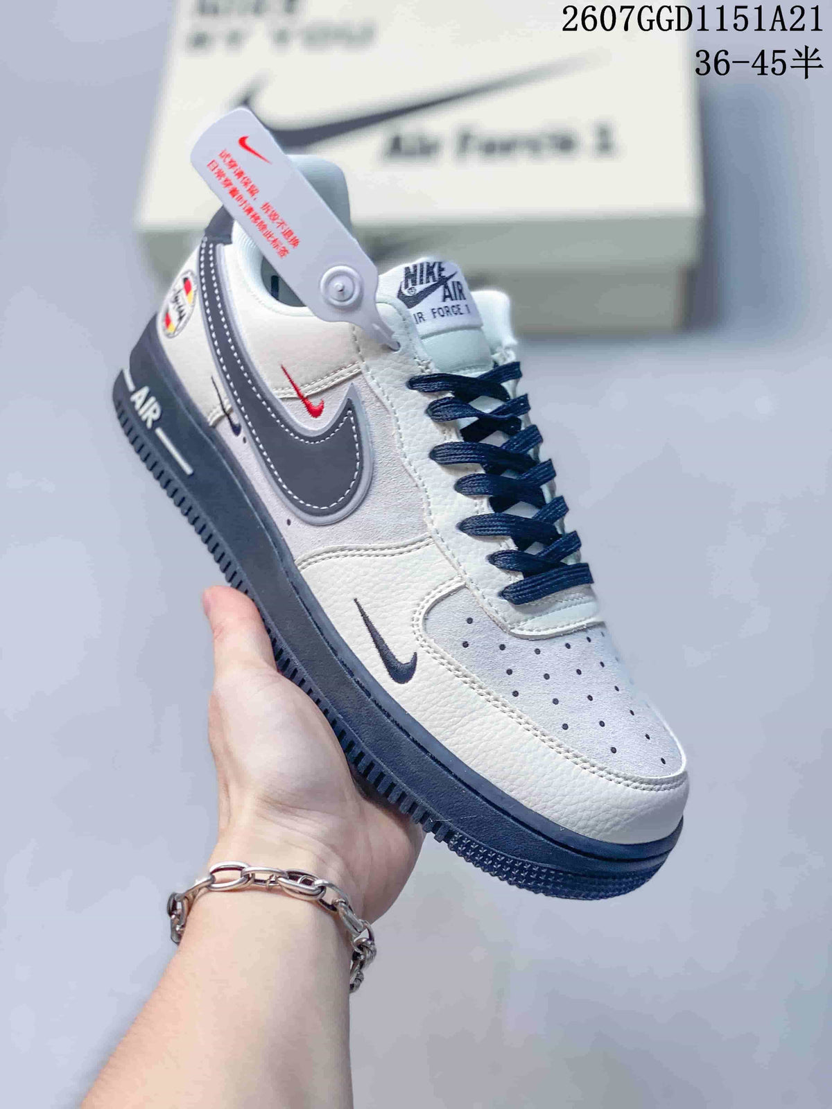 Angled side view showing the white and navy color blocking, layered Swoosh details, heel branding, and navy outsole.