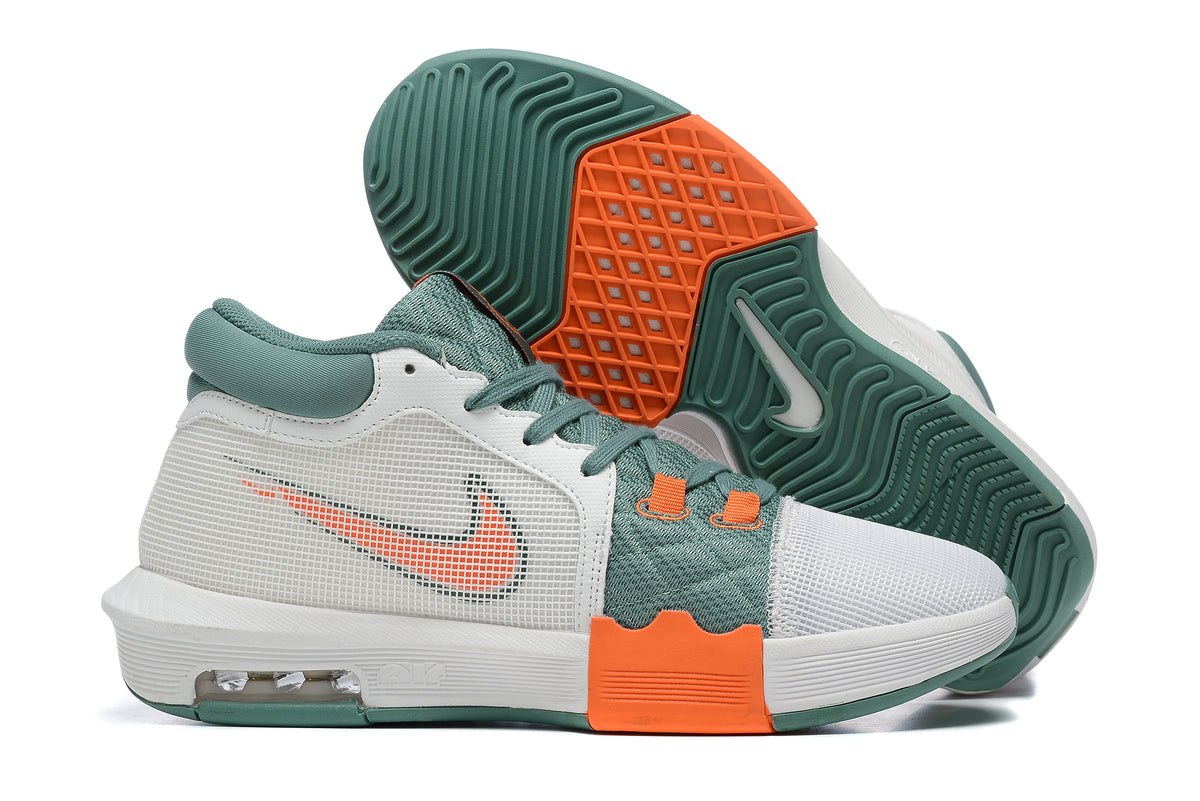 White low-top basketball shoes with green and orange accents, shown from the side and outsole.