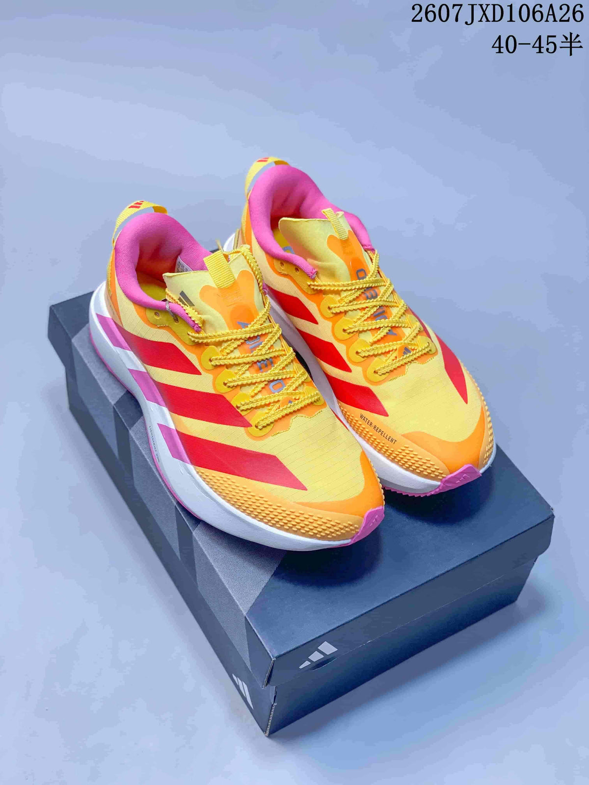 Pair of adidas Adizero Evo SL ATR shoes in yellow, red and pink displayed on a shoebox.