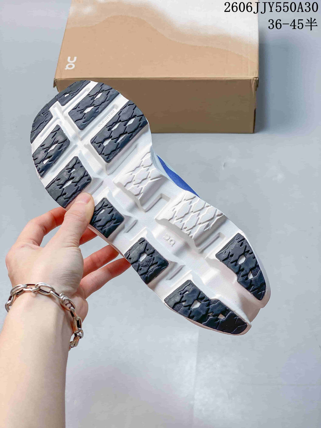 Underside of the running shoe showing white sole sections and dark tread
