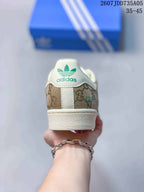 Rear view showing the Adidas trefoil heel logo, beige patterned panels, and off-white heel detail.