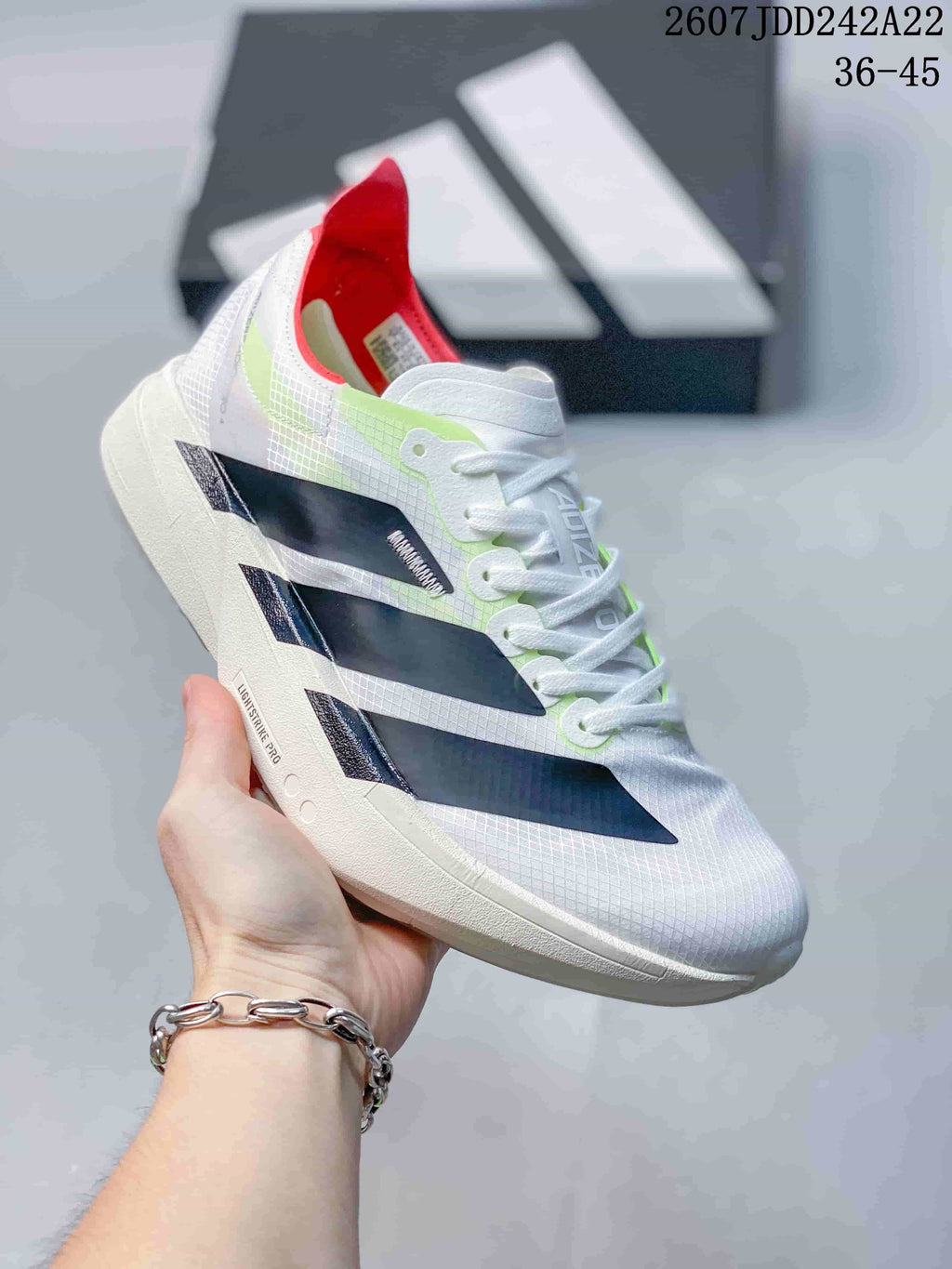 Angled side view showing the white textured upper, layered black side panels, red collar, and sculpted sole.