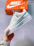 Side profile of a cream-white Air Force 1 sneaker with patterned panels and dark accents