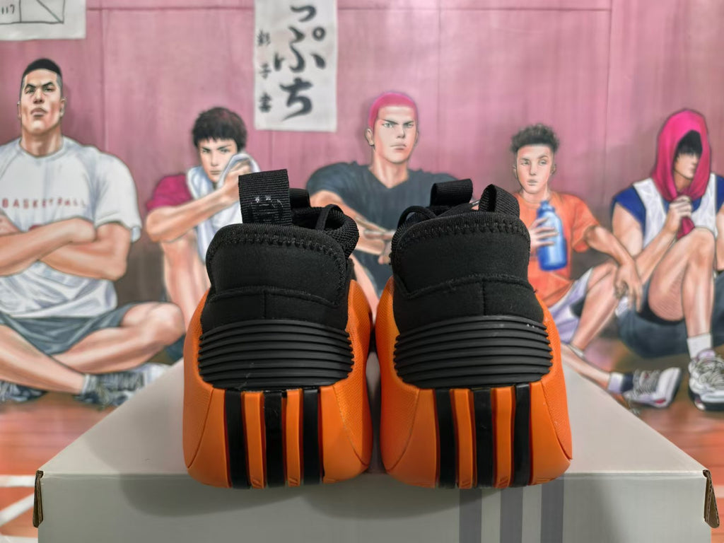 Rear view of black and orange basketball sneakers showing padded heels and sculpted outsole details