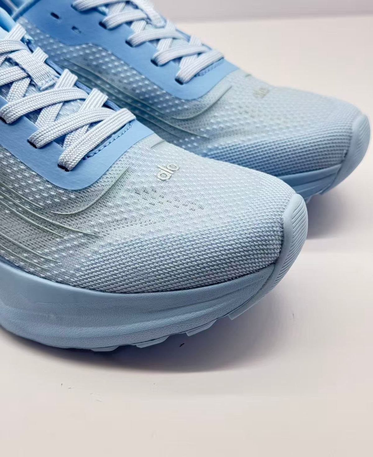 Close-up of the textured toe area, woven laces and visible Alo branding.