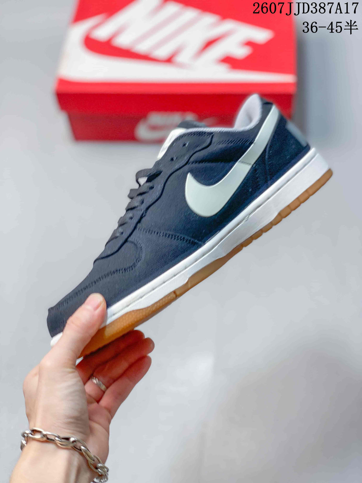 Side profile of the navy low-top sneaker showing the white Swoosh, white midsole, and gum-colored outsole.