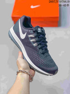 Close side view of a dark gray Nike running shoe with white branding, textured upper and contrasting midsole.