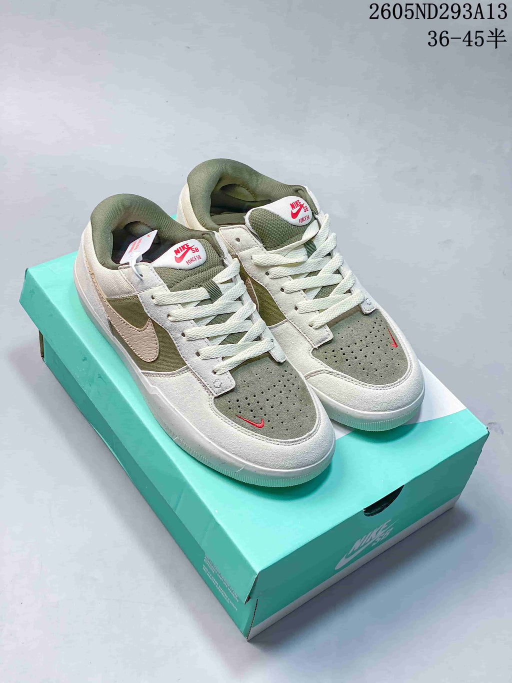Pair of white and muted green Nike SB Force 58 low-top sneakers displayed on a turquoise shoebox.