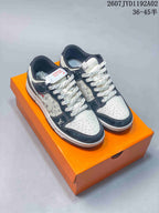 Pair of white and navy low-top sneakers with monogram-style panels and patterned laces