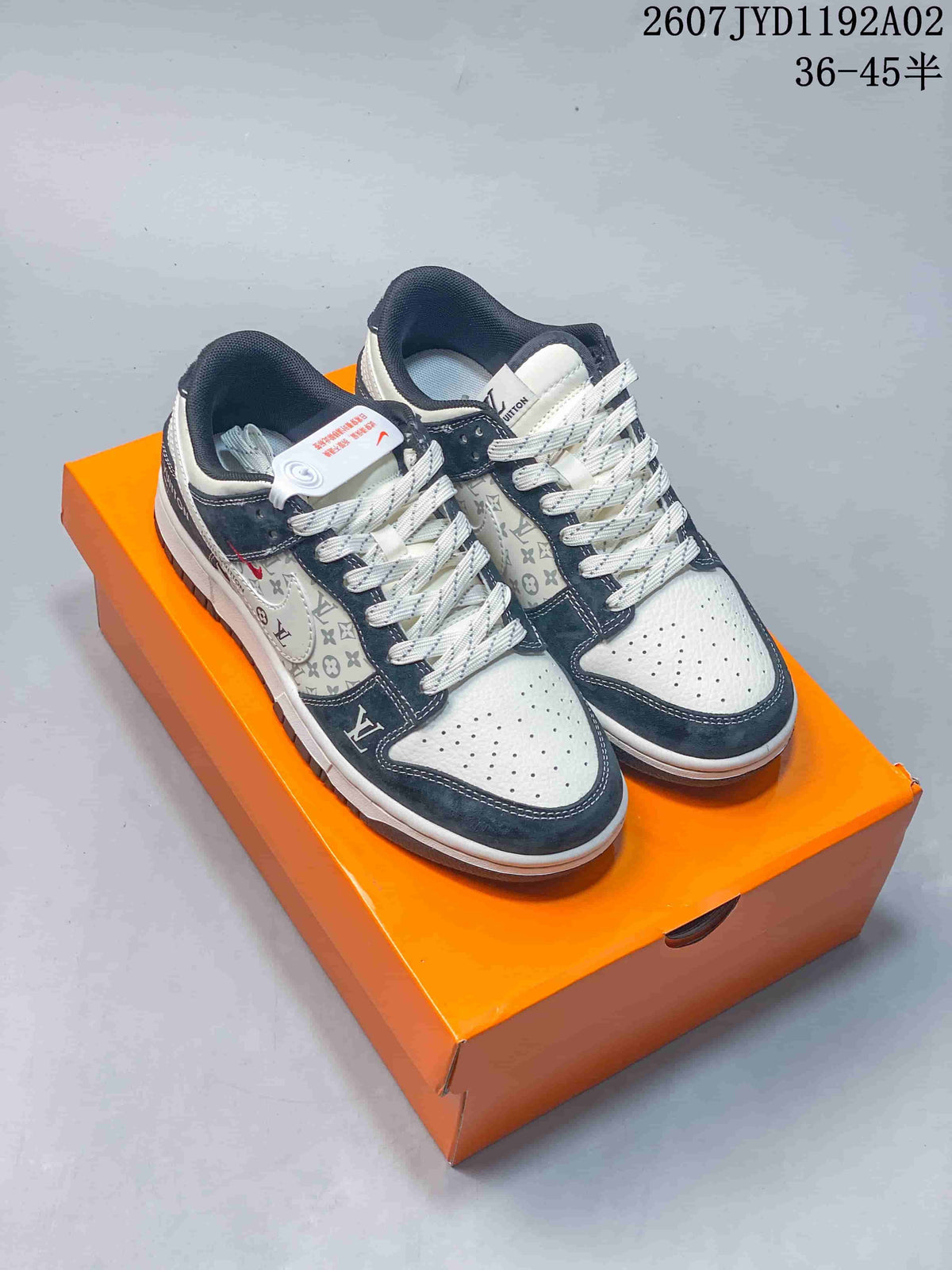Pair of white and navy low-top sneakers with monogram-style panels and patterned laces