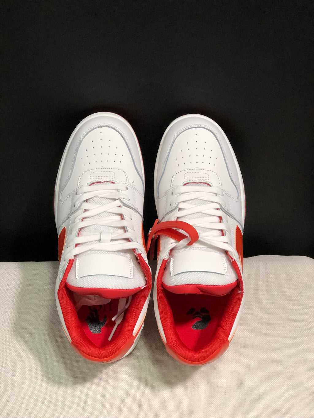 Top-down view showing the perforated toe boxes, white laces, and red interior padding.