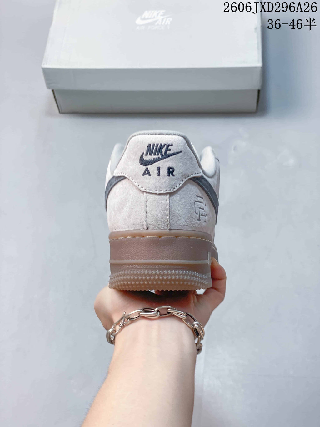 Rear view of a light-colored Nike Air Force 1 sneaker with gray heel accents