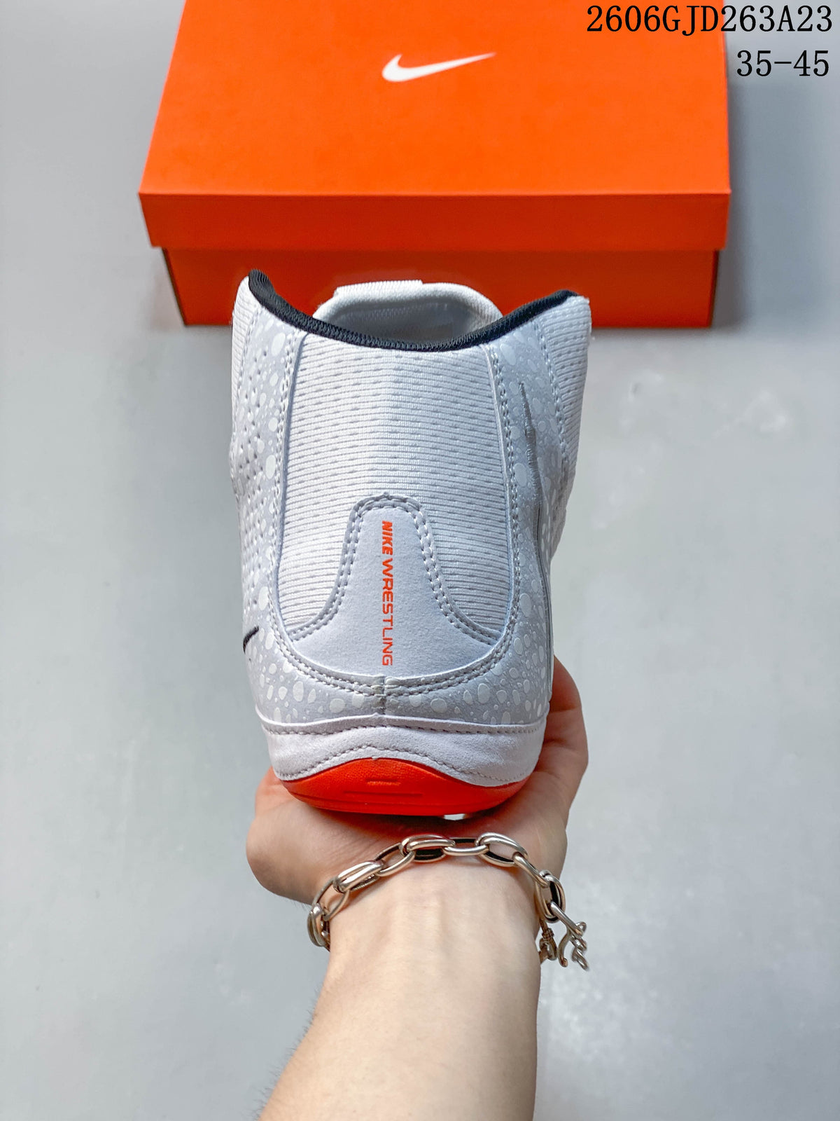 Rear view of the shoe with patterned grey overlays and orange heel detail