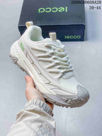 Angled side view of the white sneaker showing its layered design and tread.