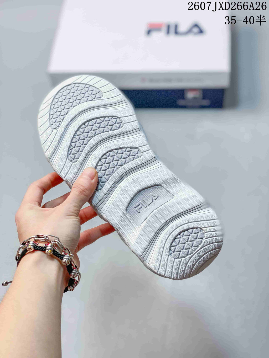Close-up of the textured white and gray outsole showing segmented tread areas and FILA branding.