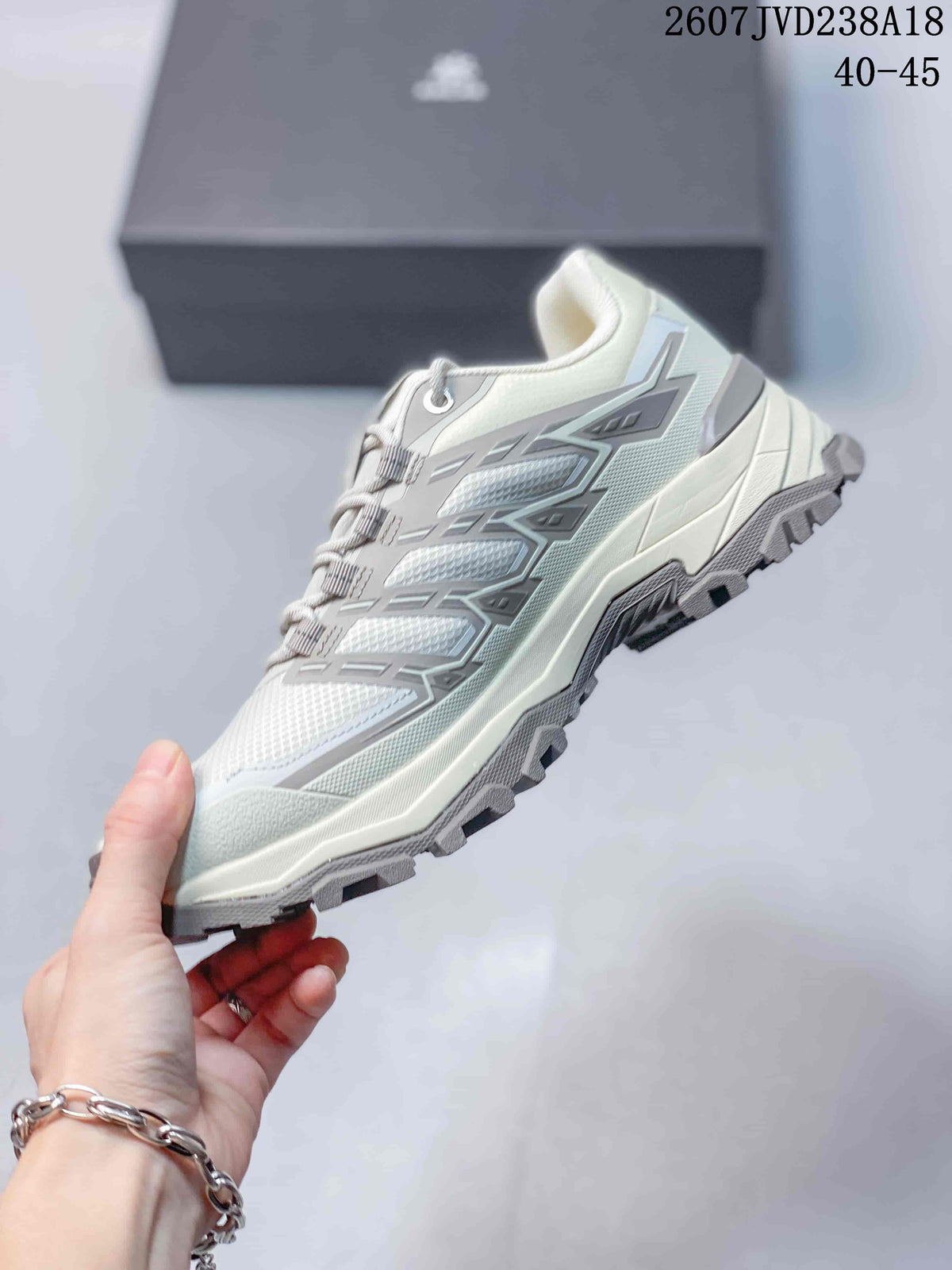 Side profile of the white and gray low-top hiking shoe showing its structured upper, layered overlays, and rugged outsole.