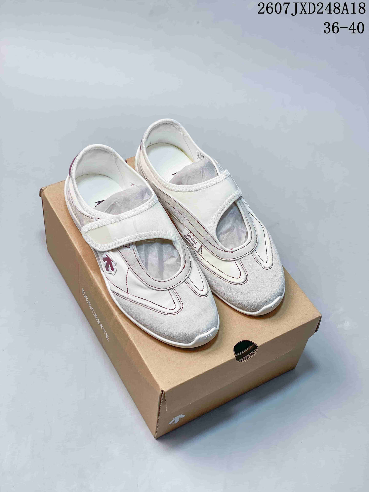 White Descente Edge Court Retro low-top sneakers with wide straps shown on a shoebox; image overlay shows code 2607JXD248A18 and sizes 36–40.