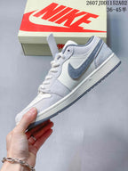 Side profile showing the white and light gray upper, gray Swoosh, and textured panels.
