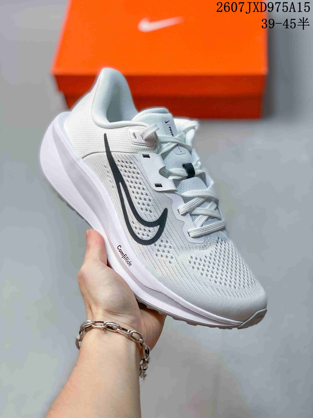 Close-up of a white Nike Quest 6 sneaker with a black side mark and perforated upper.