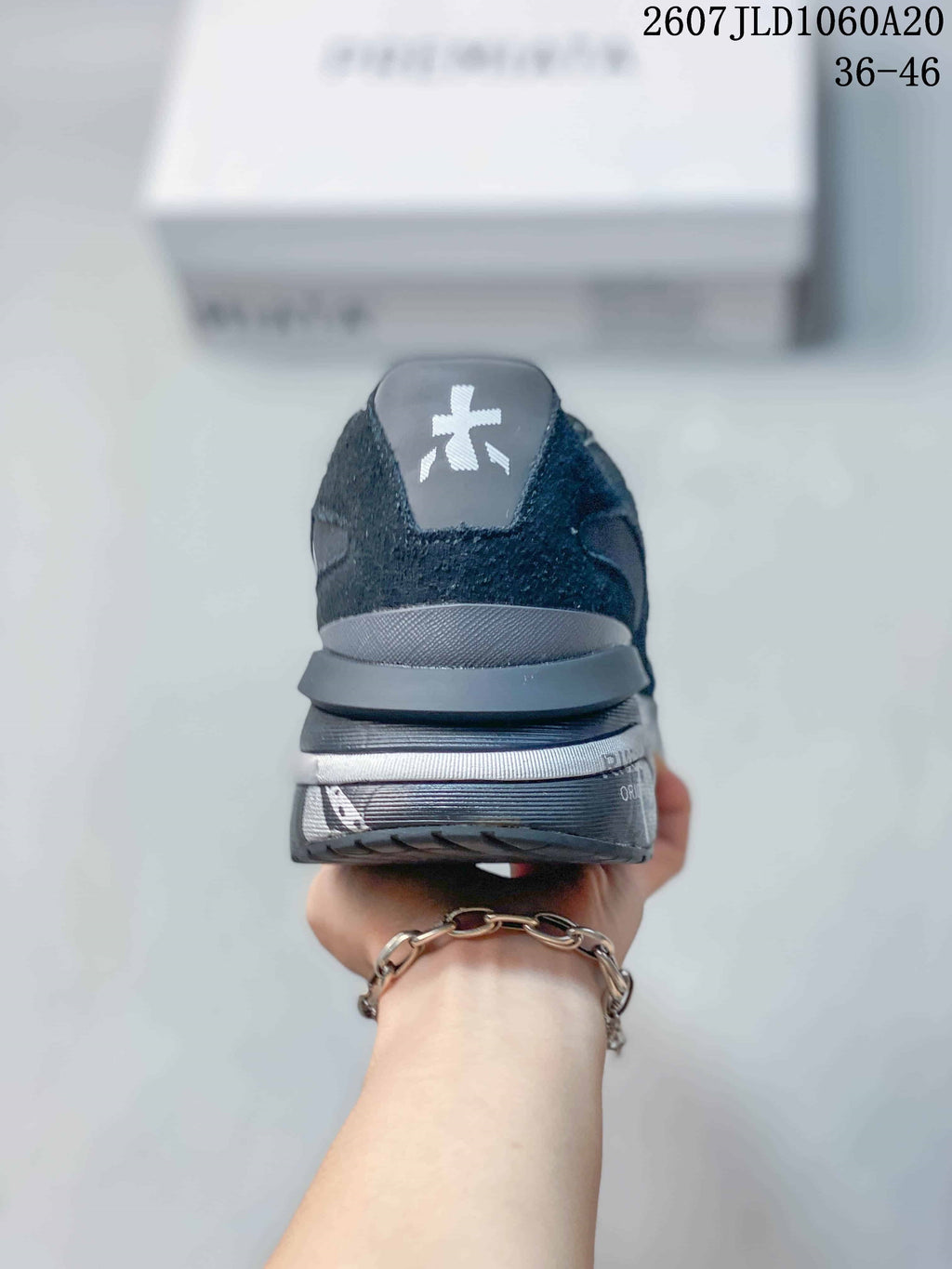 Rear view of the black and gray trainer showing the padded heel, layered sole, and heel logo detail.