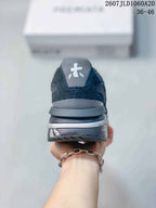 Rear view of the black and gray trainer showing the padded heel, layered sole, and heel logo detail.
