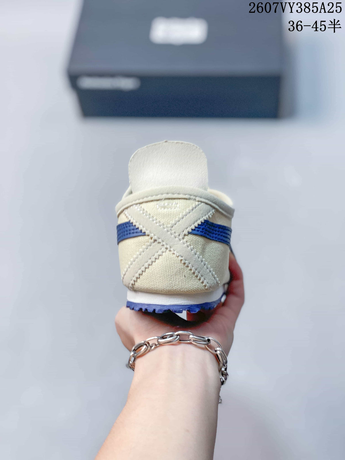 Rear view of the cream sneaker showing blue side stripes, heel construction, and the low-cut slip-on opening.