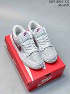 Pair of white and red Nike low-top sneakers displayed on a red shoebox, with the style code and size range visible above.