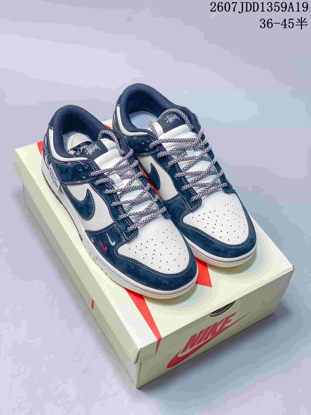Pair of navy and white Jordan low-top sneakers displayed on a branded shoebox.